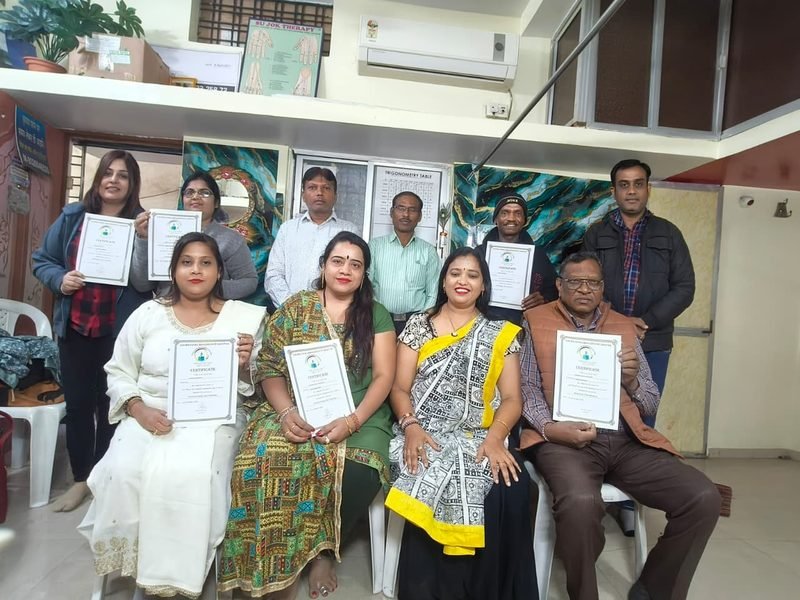 Course participants holding their certificates, seated and standing around Dr. Abha Jain