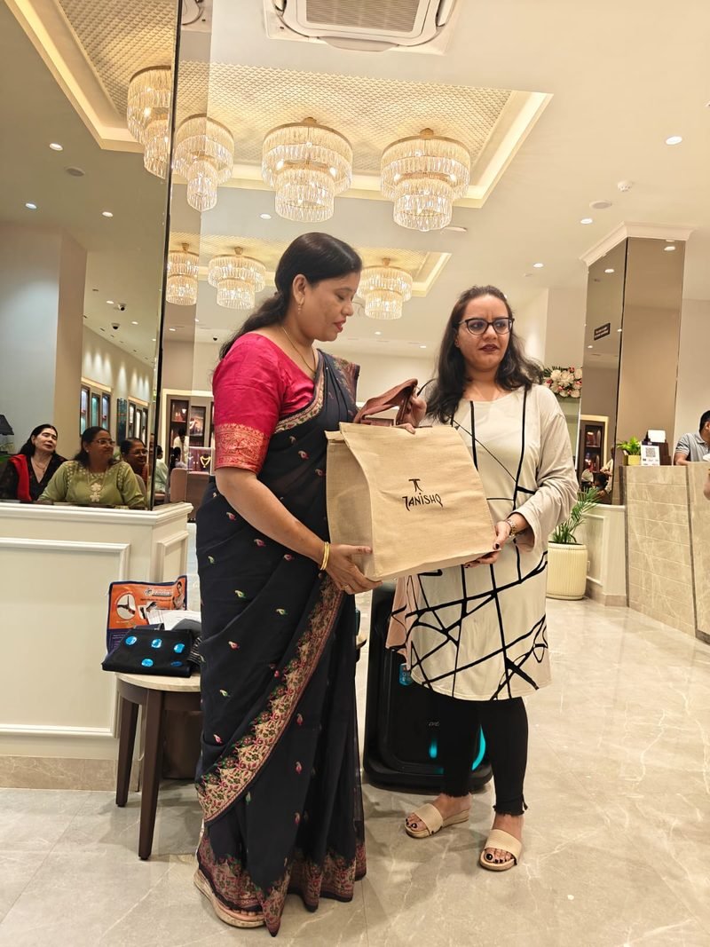 Dr. Abha Jain being presented with a gift at a wellness session in a showroom, with guests seated behind